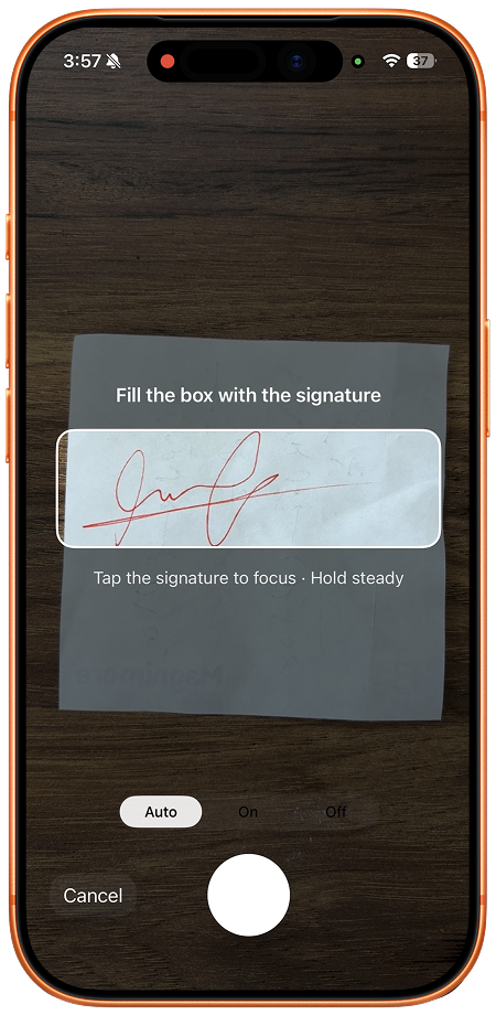 The dedicated signature camera guide framing a handwritten red-ink signature on paper.